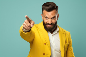 Man wearing bright yellow jacket is pointing directly at camera. This image can be used to convey sense of confidence, authority, or engagement with viewer. - Powered by Adobe