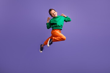 Fototapeta na wymiar Photo of overjoyed nice boy wear green trendy outfit raise fist have fun enjoy rejoice shopping sale isolated on purple color background