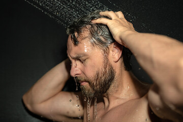 Man washing hair closeup portrait. Bathing shower washing hair head in bathroom. Male model washing...
