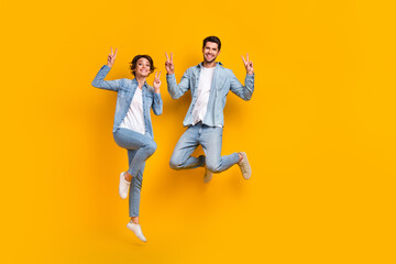 Fototapeta na wymiar Full length photo of crazy funky cheerful people stylish jeans clothes have fun black friday sale isolated on yellow color background