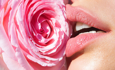 Tenderness rose. Tender natural lips with pink rose. Tenderness sexy woman mouth. Caring and tenderness. Close-up beautiful tender lips with pink rose flower. Spa and cosmetics. Tenderness touch.