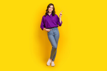 Fototapeta premium Full size portrait of stunning positive girl direct finger empty space ad proposition isolated on yellow color background