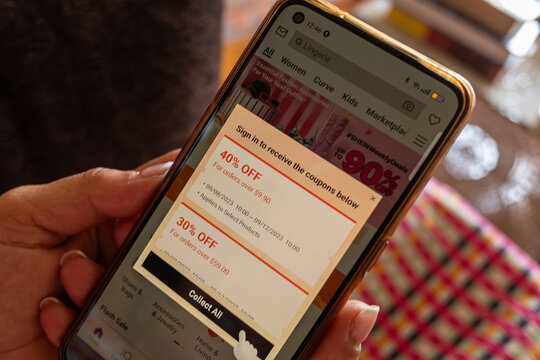 Selective focus, Female hand looking at the Shein app on a smarphone