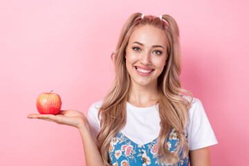 Portrait of gorgeous cheerful lady beaming smile arm palm hold fresh apple fruit ripe isolated on pink color background