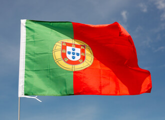 Portuguese nationale green-red flag waved on blue sky background.