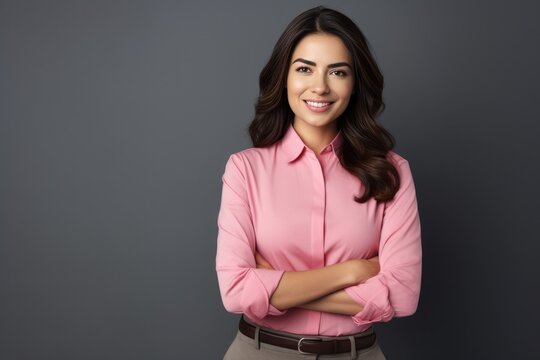 Happy young smiling confident professional business woman wearing pink shirt, pretty stylish female executive looking at camera, standing arms crossed isolated at gray background, 