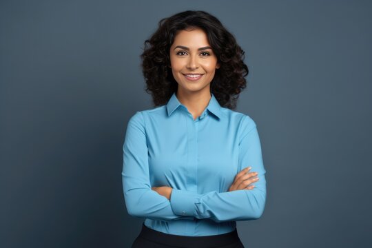 Happy young smiling confident professional business woman wearing blue shirt, pretty stylish female executive looking at camera, standing arms crossed isolated at gray background,