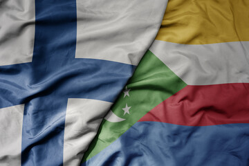 Obraz premium big waving national colorful flag of finland and national flag of comoros .