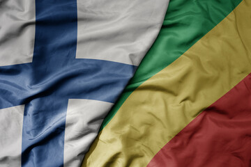 big waving national colorful flag of finland and national flag of republic of the congo .