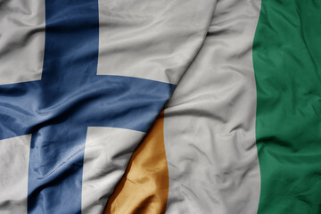 big waving national colorful flag of finland and national flag of cote divoire .