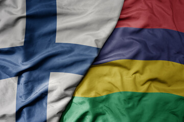 big waving national colorful flag of finland and national flag of mauritius .