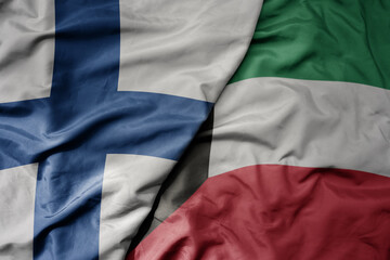 big waving national colorful flag of finland and national flag of kuwait .