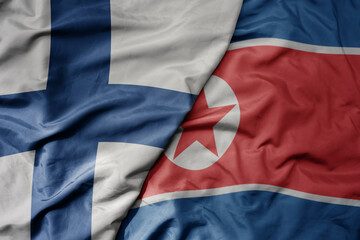 Fototapeta premium big waving national colorful flag of finland and national flag of north korea .