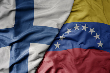 big waving national colorful flag of finland and national flag of venezuela .