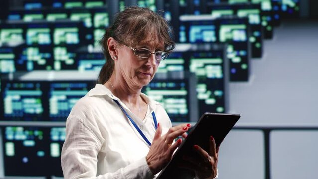 Meticulous tech support woman in data center equipped to handle complex computing operations, doing regular upgrades to server components, increasing processing power to prevent crashes