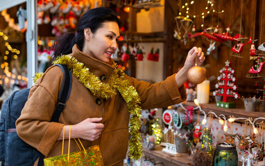 Asian woman buying decorations while visiting christmas fair.