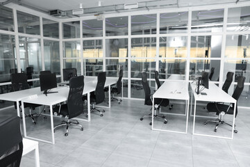 Stylish interior of open plan office. Workspace with computers, tables and chairs