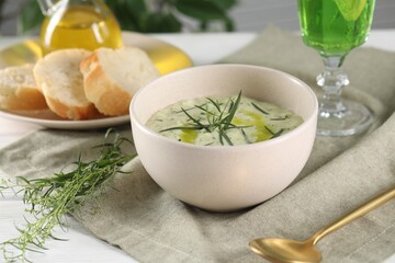 Delicious cream soup with tarragon, spices and potato in bowl served on white table