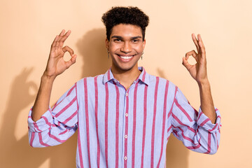 Portrait of handsome young worker guy wearing formal clothes showing okay symbol hands isolated beige color background