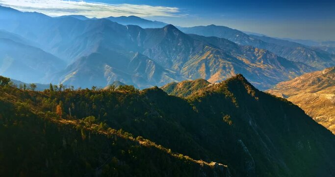 Pointed tops of California mountains lit with bright sun. Beautiful rocky view from aerial perspective.