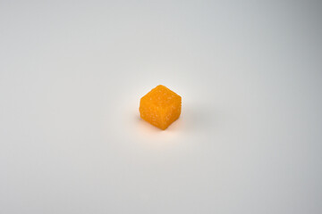 One mango-flavored jelly candy on a white background