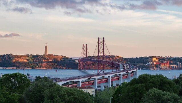 Time-lapse of Lisbon view from Miradouro do Bairro do Alvito tourist viewpoint with Tagus river, traffic on 25th of April Bridge and Christ the King statue on sunset. Lisbon, Portugal, Europe