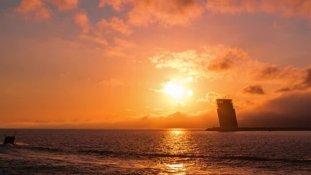 Time-lapse of Torre VTS de Lisboa, VTS Vessel Traffic System tower Centre for Coordination and Control of Maritime Traffic and Safety of Lisbon on bank of Tagus river, Portugal on sunset. Camera pan
