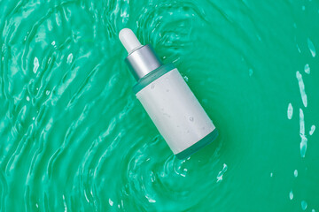 Moisturizing facial essence on a green background. Serum in the waves. Anti-aging cosmetics. Mockup.