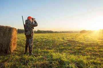 Foto op Plexiglas Male with a gun looking in binoculars. Hunter man. © Sergey