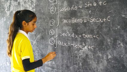 Happy Rural School Girl wearing School Uniform Standing in Front of A Black Board. - obrazy, fototapety, plakaty