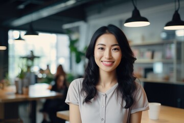 Obraz premium Smiling portrait of a happy asian woman working for a modern startup company in a business office