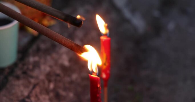 Lilting flame on joss sticks from candle flame for burning on Chinese hungry ghost festival 