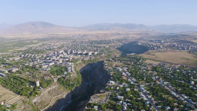 Slide aerial shot of Hrazdan canyon, Arzni and Nor Geghi villages on sunny summer day. Kotayk Province, Armenia.