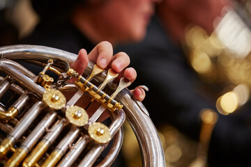 Fototapeta premium Close up of person hands playing horn