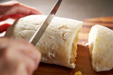 cutting bread with a knife on a cutting board