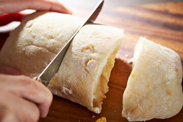 cutting bread with a knife on a cutting board