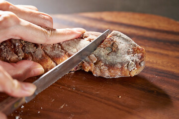 cutting bread with a knife on a cutting board