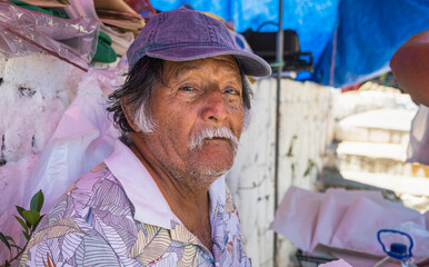 Old latino man posing and eating sweet bread in El Salvador, typical food of El Salvador. With sweet bread in the foreground