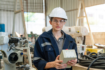 Portrait of female automation engineer standing and looking camera in industrial factory.