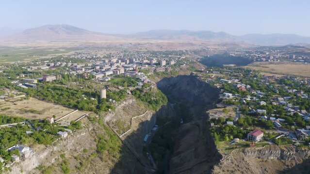Forward reveal aerial shot of Hrazdan canyon, Arzni and Nor Geghi villages on sunny summer day. Kotayk Province, Armenia.