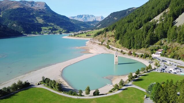 Aerial drone footage of the famous bell tower of the submerged Venosta Vecchi church in the Resia lake in the alps in northern Italy in South Tyrol province