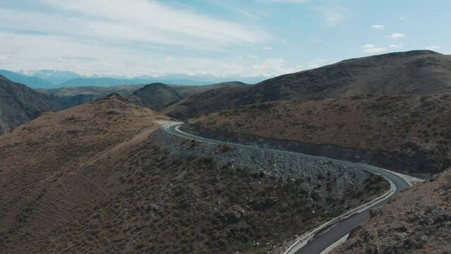 This stock video shows aerial photography of a highway high in the mountains on a summer day. This video will decorate your projects related to nature, highways, travel, tourism.