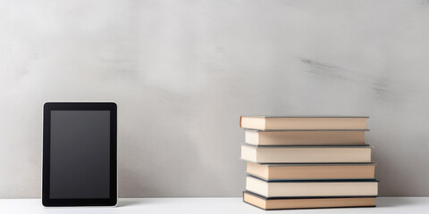 Reader and hardcover books on light grey table