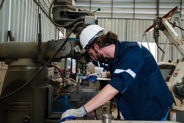 Male technician worker checking and repair pressing metal machine at factory, Machine maintenance technician operation concept.