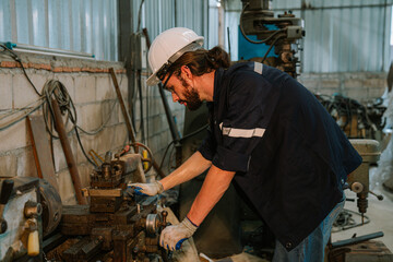 Male technician worker checking and repair pressing metal machine at factory, Machine maintenance technician operation concept.