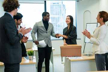 Beautiful young female carrying office box, hired for a new job, multiethnic colleagues welcome and...