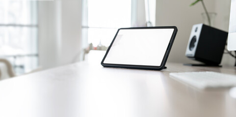 Blank screen digital tablet on the table, creative work space.