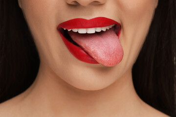 Woman with red lipstick showing her tongue, closeup