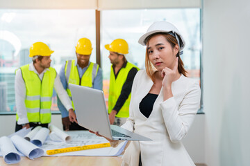 Portrait of Female inspectors holding laptop and architects discuss with head engineer about construction project, team discussion with construction on site work.	