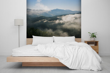 Light bedroom. Interior with comfortable bed and mountain landscape wallpapers